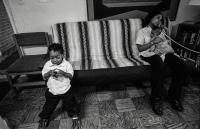 Nineteen year old Tiffany Jefferson holds her daughter while using the office phone in  The Sullivan House, which is a shelter for homeless families in Arlington Virgina.  She lives there with her two children. Tiffany grew up living in shelters and now finds herself living in one with her two children, one who has many health issues.
